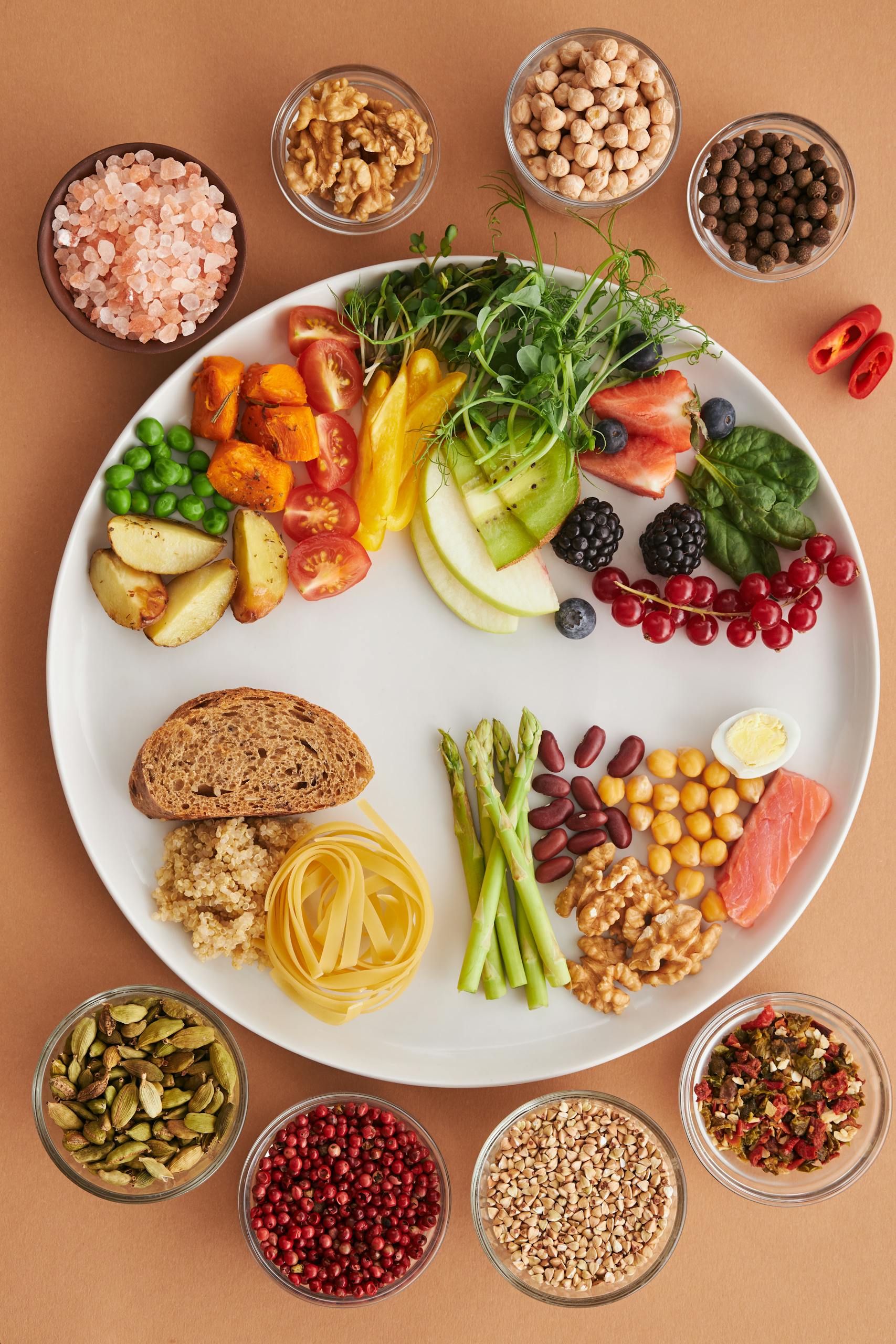 A vibrant assortment of healthy foods on a plate, showcasing a balanced diet with fruits, vegetables, nuts, and grains.